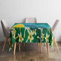 Turquoise tropical tablecloth with green foliage and yellow lilies on dining table