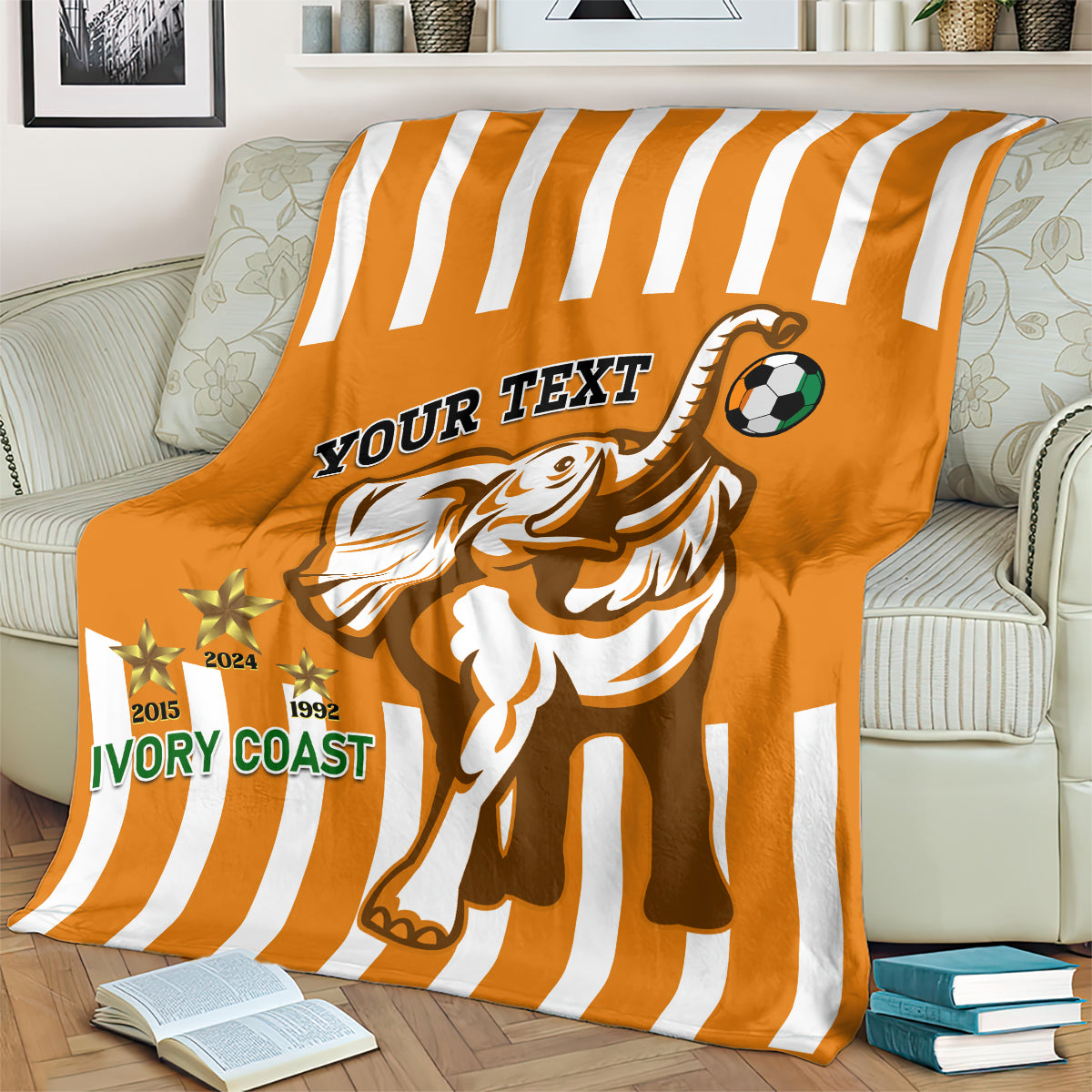 Football blanket in orange with white stripes, elephant mascot and soccer ball graphics