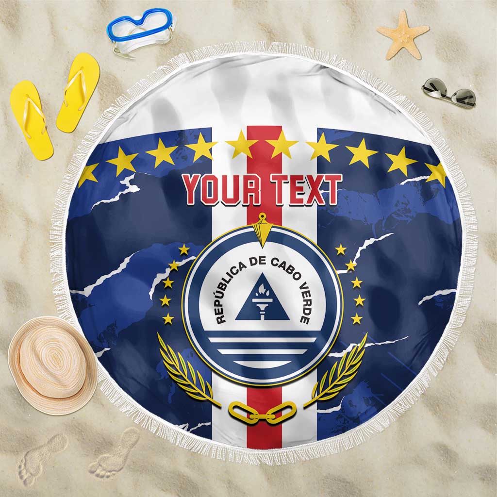 Round blue beach blanket with white fringe, featuring Cabo Verde emblem and stars