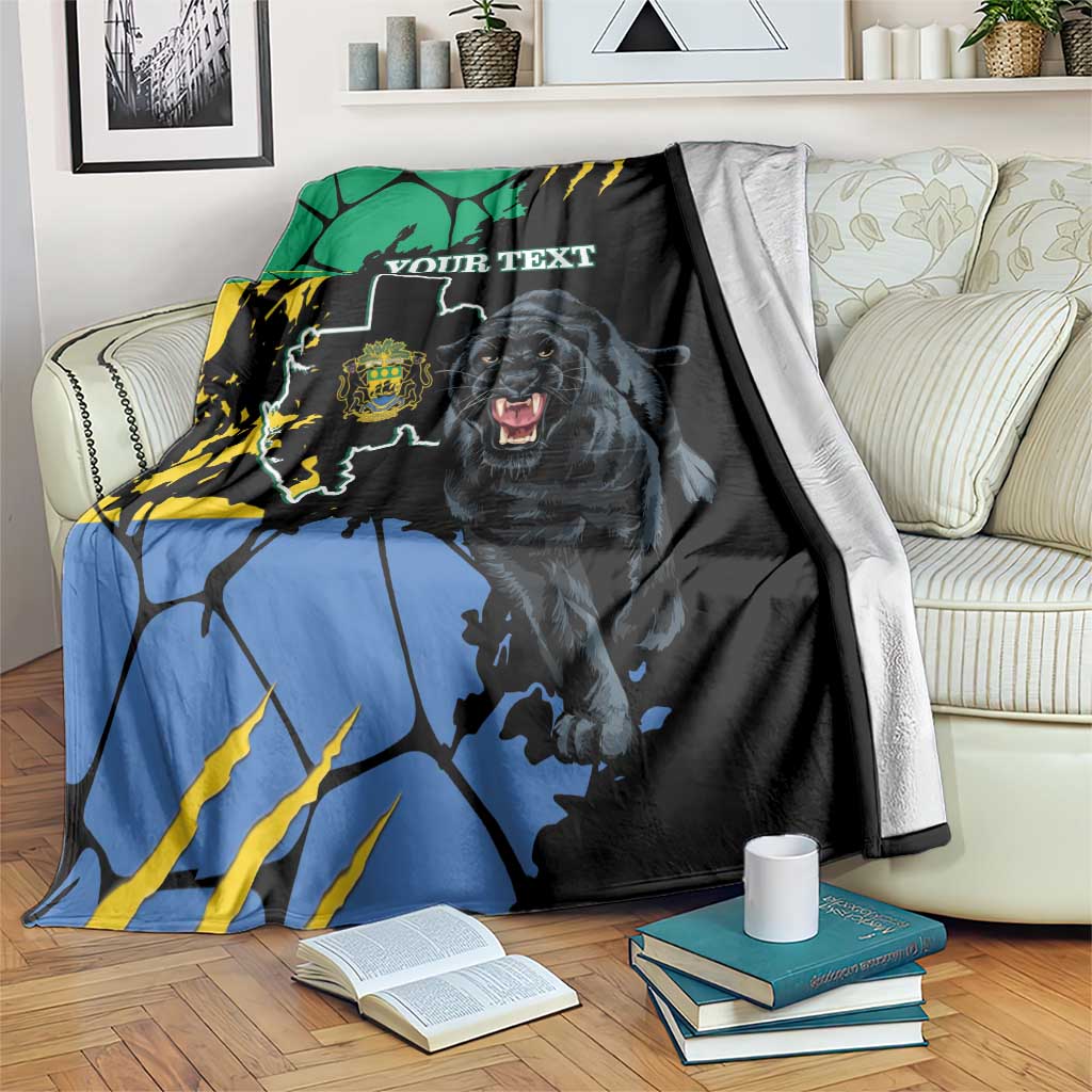 Black throw blanket draped on sofa, showing panther, map shapes in blue/green/yellow