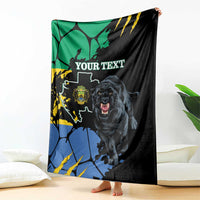 Black blanket held upright with panther and map-style pattern in blue, green, yellow