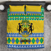Yellow duvet with green and blue holiday pattern, crest and “GABONESE” text, two pillows.