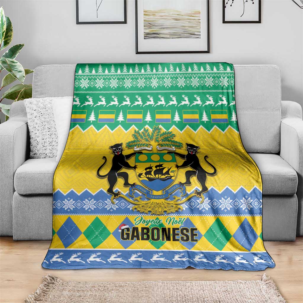 Green, yellow and blue Christmas blanket draped on sofa with coat of arms and pine trees
