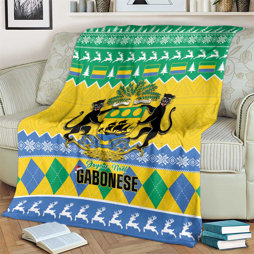 Green, yellow and blue Christmas blanket over couch with coat of arms, trees and reindeer border