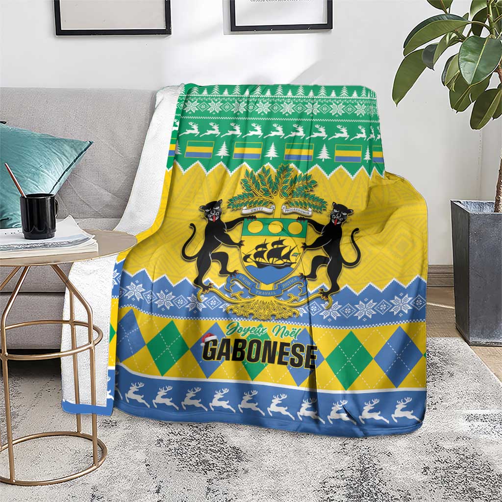 Green, yellow and blue Christmas blanket on chair with coat of arms, pine trees and reindeer border