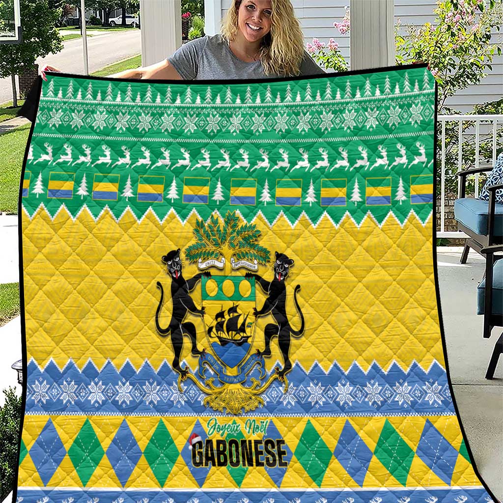 Quilt blanket held outdoors, green top, yellow middle, blue bottom with lion crest emblem.