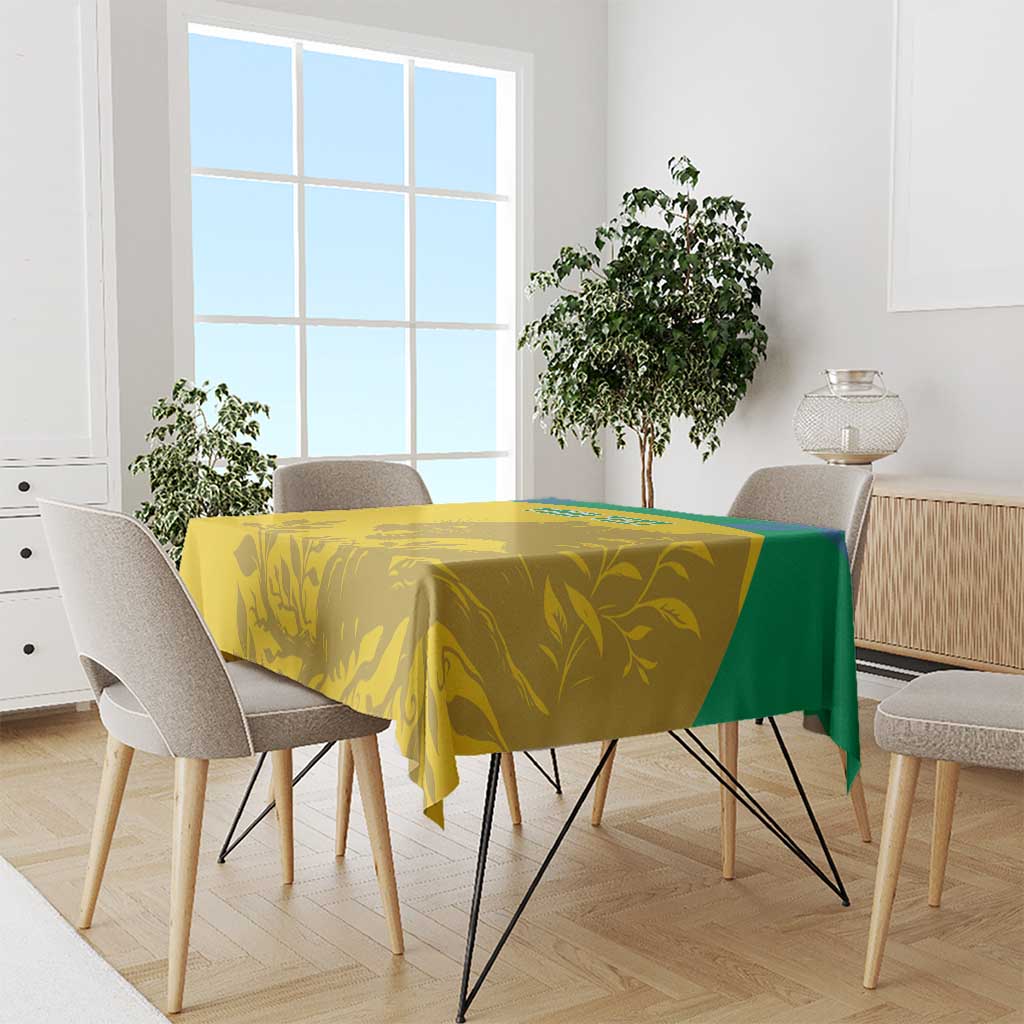 Yellow tablecloth with green border and gold animal-and-leaf print over dining table