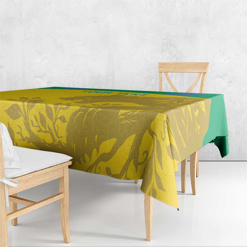 Yellow tablecloth with green trim and gold animal-and-leaf pattern on table