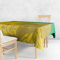 Yellow tablecloth with green trim and gold animal-and-leaf pattern on table