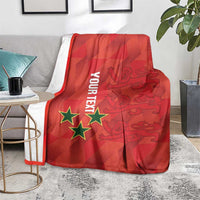Red football blanket with stars and map graphic, draped on a gray couch