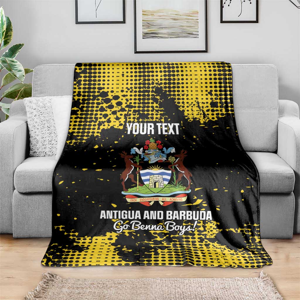 Black-and-yellow football blanket draped on a couch with Antigua crest and “YOUR TEXT”