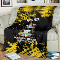Black and yellow football blanket folded on a couch, showing Antigua crest and “YOUR TEXT”