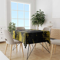 Black tablecloth with yellow speckled pattern draped on dining table