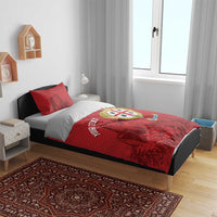Red bedding set on bed frame with two pillows, 'YOUR TEXT' and Nuraghe falcon crest