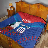Blue and red Cuba quilt blanket on bed with bird graphic, 'Cuba' and 'YOUR TEXT 00'