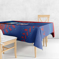 Blue tablecloth with red and teal pattern, hanging over a table edge
