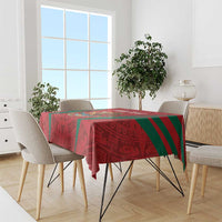 Red tablecloth with Aztec-style calendar pattern, green stripe accents on dining table