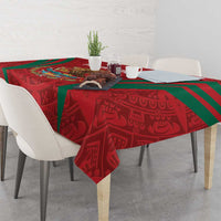 Square tablecloth in red with Aztec-style figures pattern and green diagonal bands