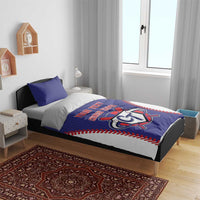 Blue bedding set on a bed with baseball-style CT logo and red stitched detailing.