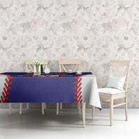 Blue tablecloth with red/white stitched edge and printed crest on dining table