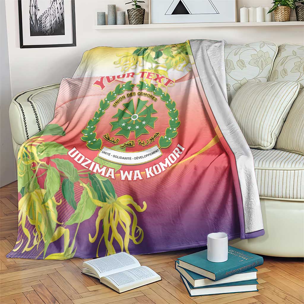 Comoros crest personalized blanket with ylang ylang motif, draped on a striped couch