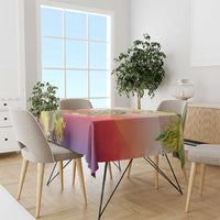 Red-purple tablecloth with green floral accents draped over a dining table