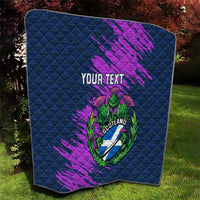 Folded navy blue quilt with purple brush strokes and Scotland thistle crest, “Your Text”