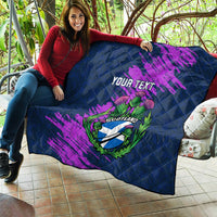 Navy blue quilt with purple brush strokes and Scotland thistle crest, “Your Text” draped on couch