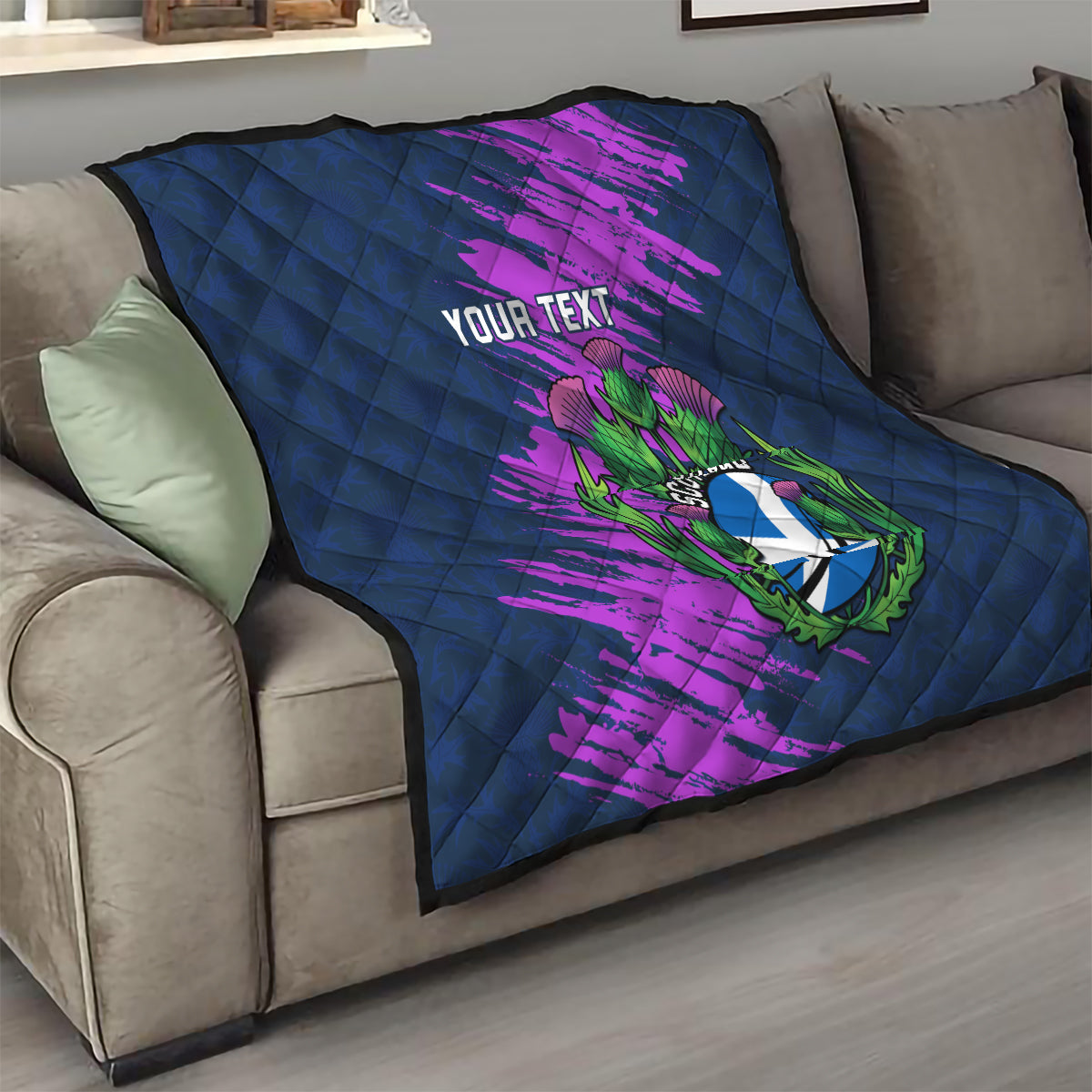 Navy blue throw quilt with purple brush strokes and Scotland thistle crest, “Your Text” on sofa