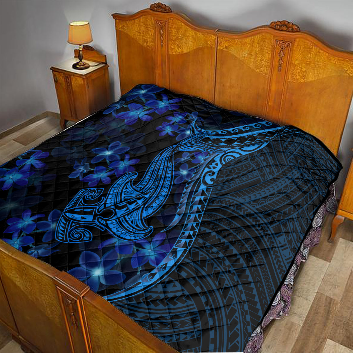 Blue shark tattoo quilt with plumeria flowers spread on a bed with dark blue fabric
