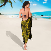 Black and gold sarong with tattoo motif, plumeria accents, and curved hem