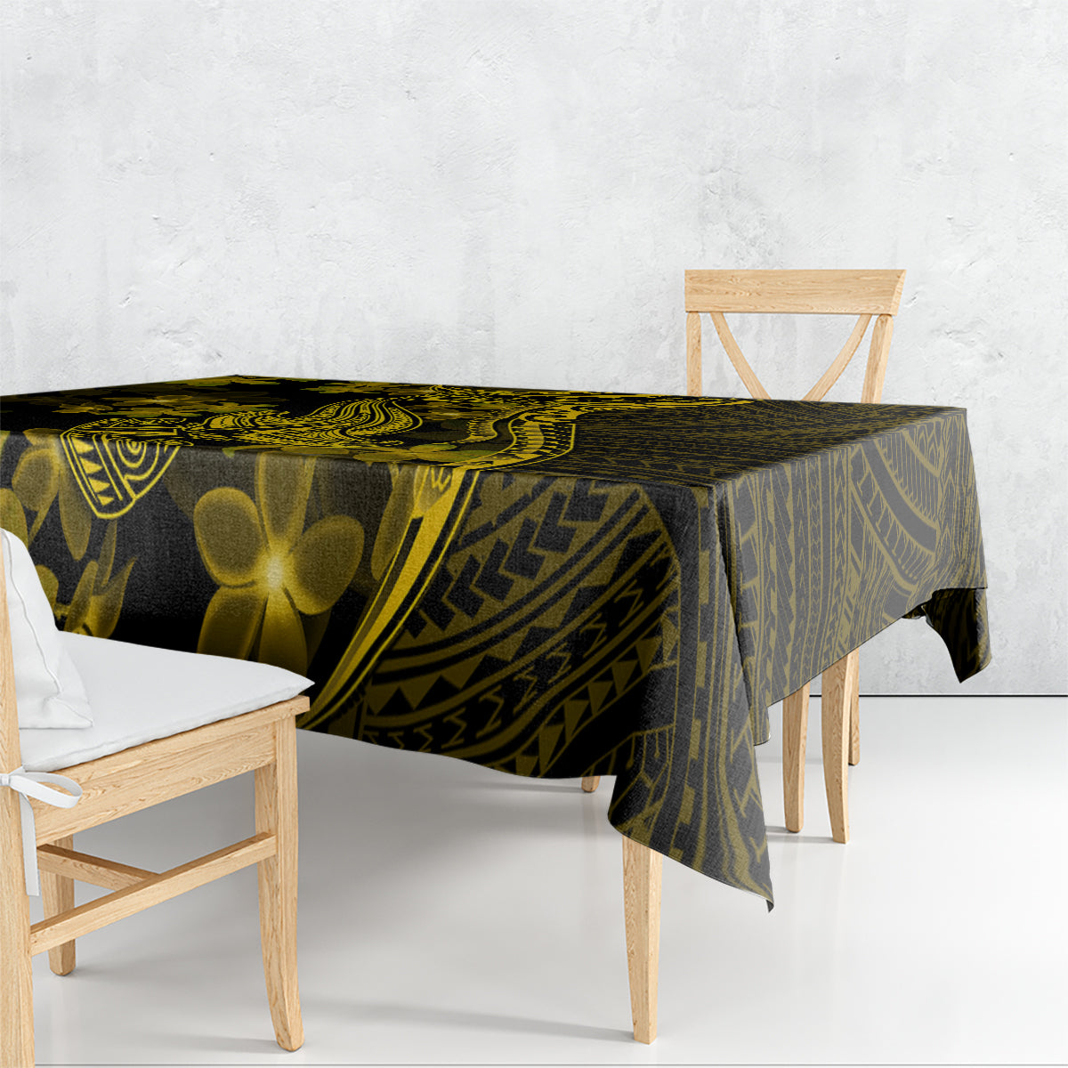 Dark tablecloth with gold tribal patterns and plumeria flowers draped over table