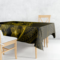 Dark tablecloth with gold tribal patterns and plumeria flowers draped over table