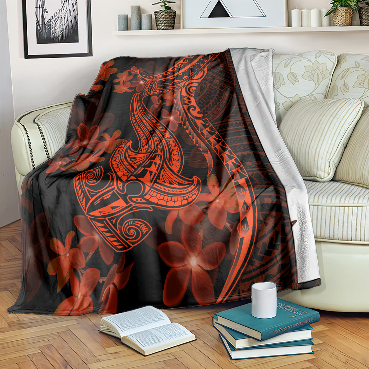 Shark tattoo style blanket on a couch, red-orange plumeria flowers on dark fabric
