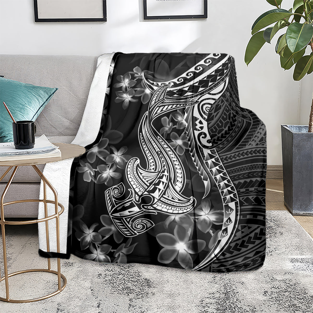 Black throw blanket showing white shark tattoo and Polynesian floral plumeria motifs