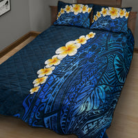 Blue quilt and two pillow covers with tropical leaf and plumeria flower design.