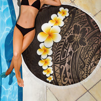 Round brown beach blanket with white fringe; dark pattern with yellow-white plumeria motif