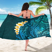 Turquoise sarong with large circular leaf motif and plumeria flowers on draped fabric
