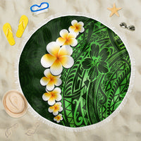 Green round beach blanket with white fringe, plumeria flowers and Polynesian leaf artwork.