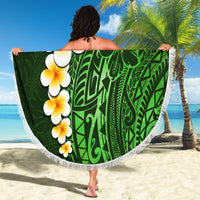 Green round beach blanket with white fringe, plumeria flowers and bold Polynesian leaf artwork.
