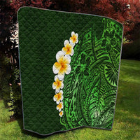 Green quilted camping-style blanket with green Polynesian pattern and yellow-white plumeria flowers.