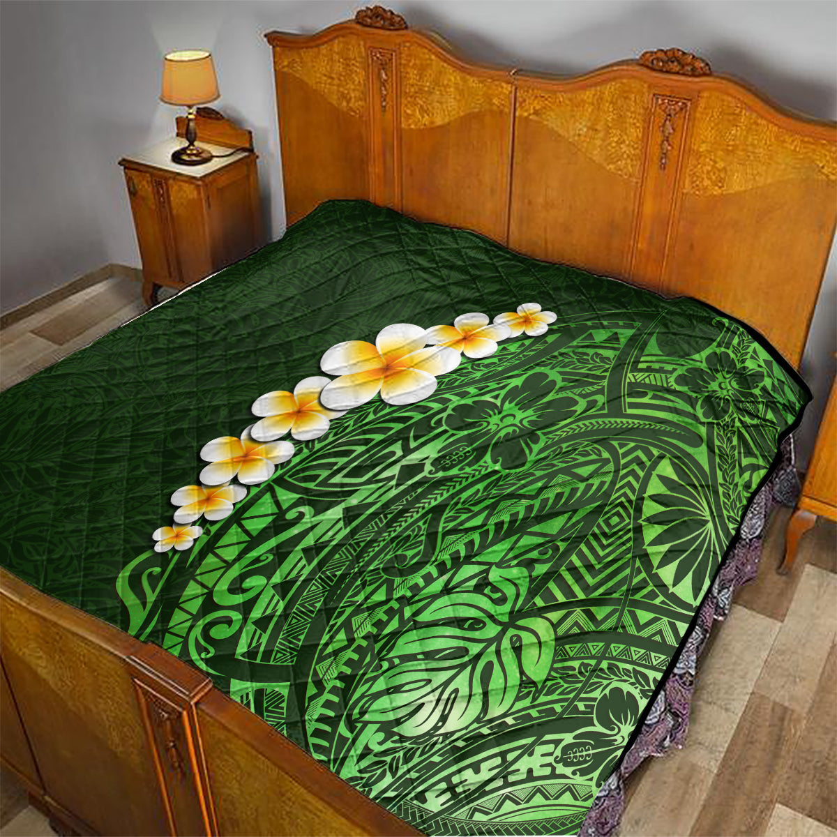 Green quilted blanket on a bed, featuring green tropical leaf pattern with yellow plumeria flowers.