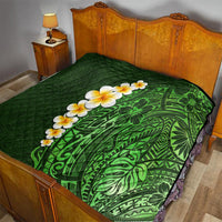 Green quilted blanket on a bed, featuring green tropical leaf pattern with yellow plumeria flowers.