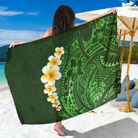 Green polynesian sarong with bold leaf pattern and white plumeria flowers, draped