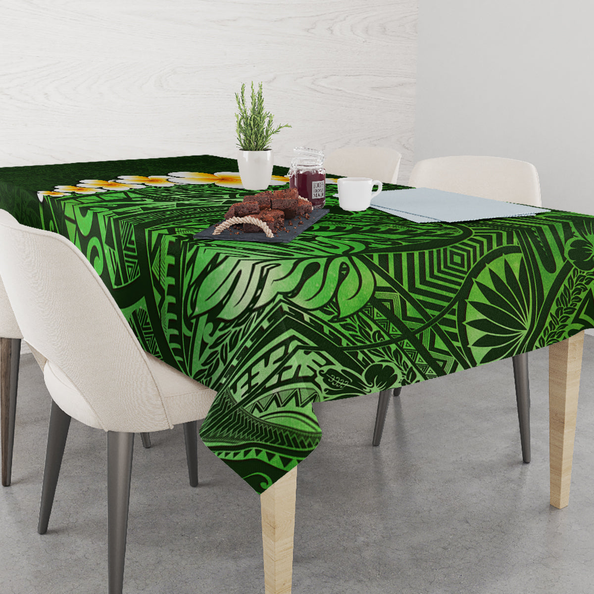 Green tropical leaf tablecloth with plumeria flowers on a dining table
