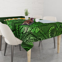 Green tropical leaf tablecloth with plumeria flowers on a dining table