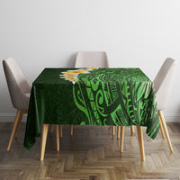 Green tropical tablecloth with bold leaf pattern and plumeria flower accents