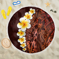 Round beach blanket with red-and-maroon tropical plumeria print and white fringe