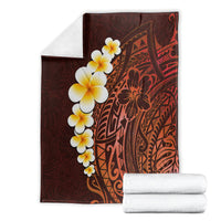 Red-brown tropical blanket with plumeria blossoms and Polynesian geometric pattern, folded
