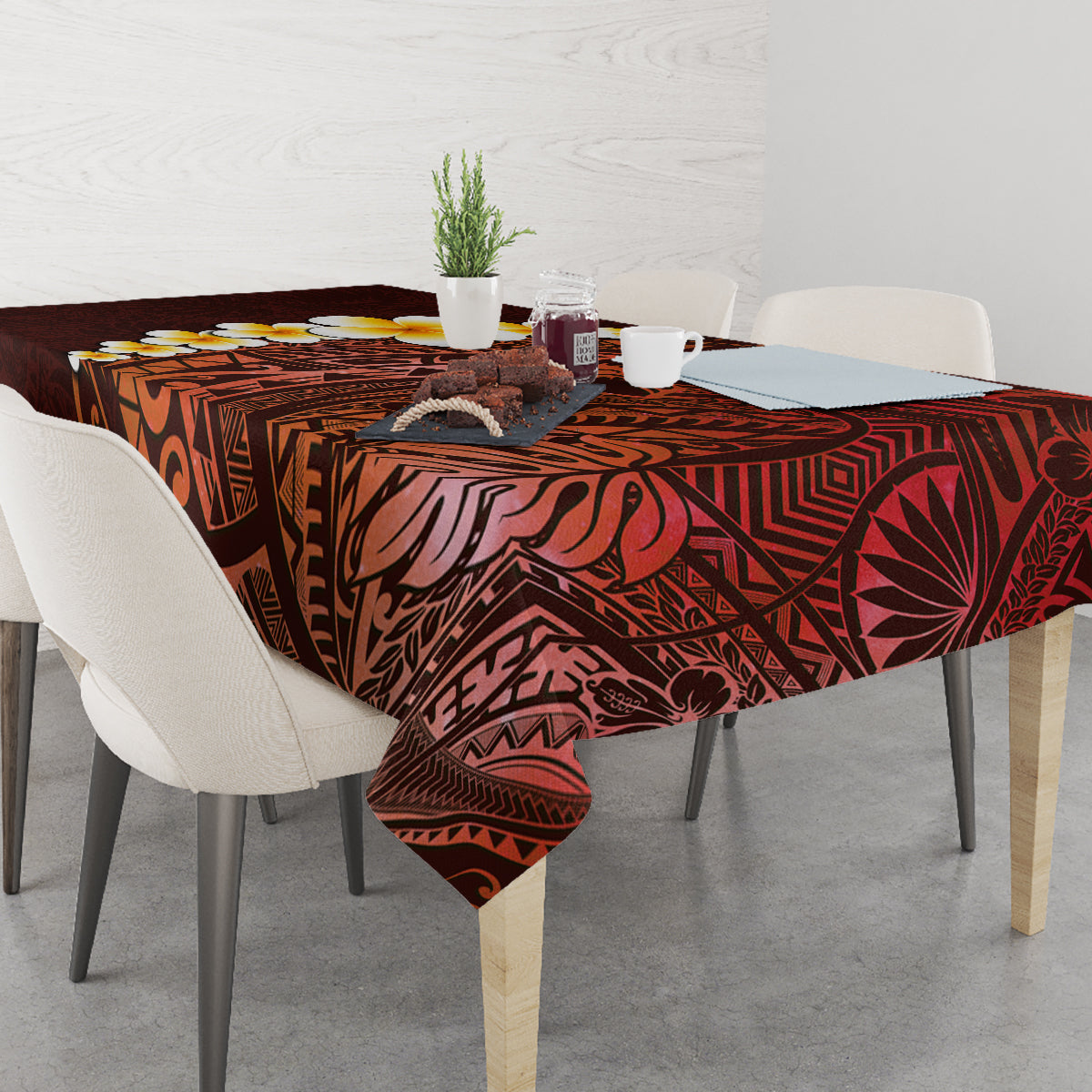 Red tablecloth with plumeria and Polynesian tribal motifs across dining table